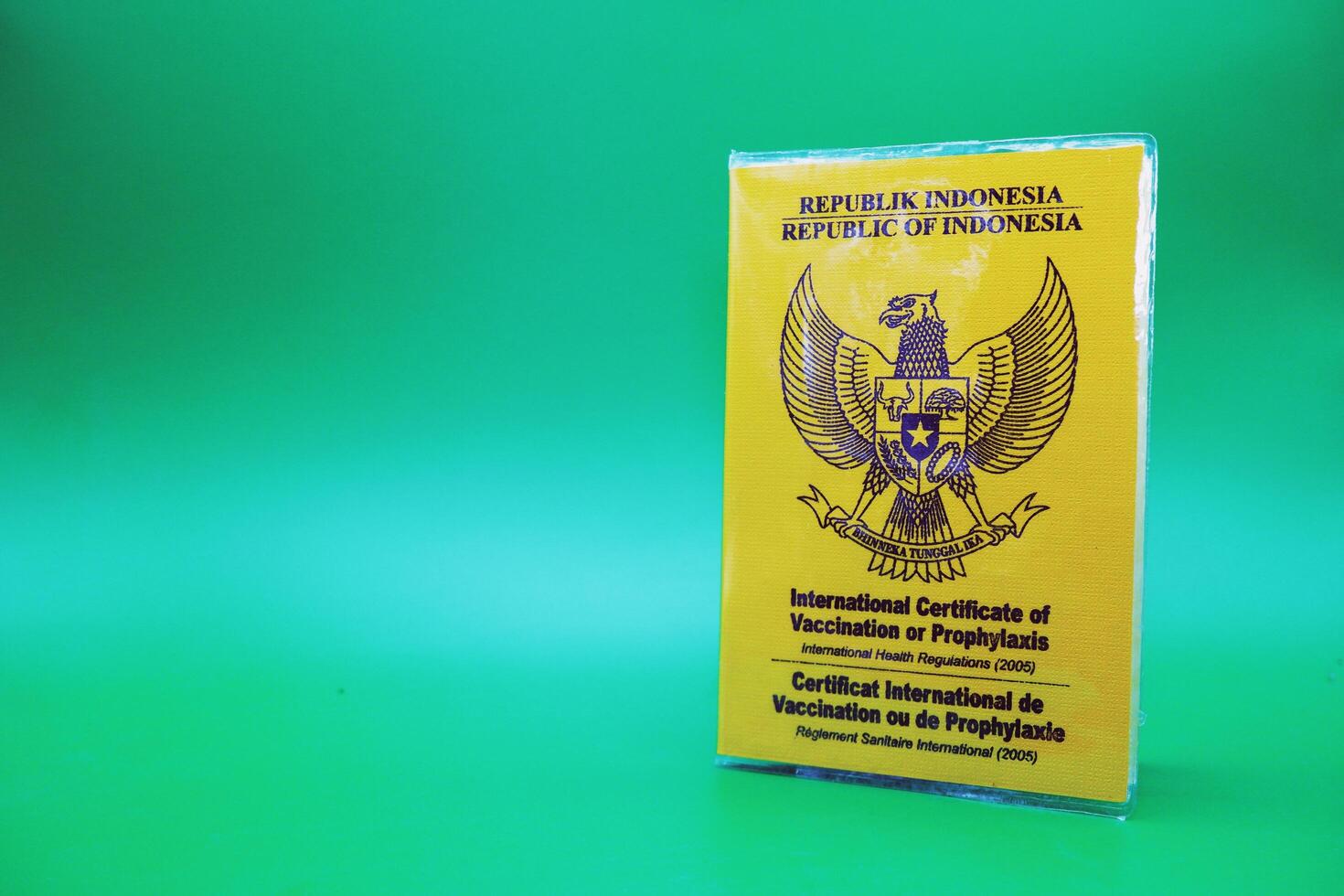 international certificate of vaccination or prophylaxis isolated on green background. yellow book as a sign of vaccination. yellow book of vaccines from indonesia photo