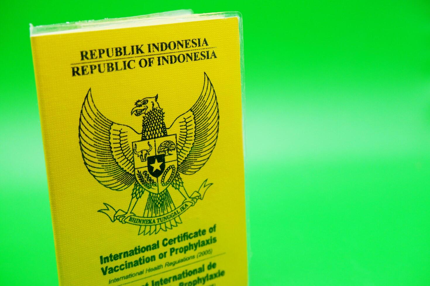 international certificate of vaccination or prophylaxis isolated on green background. yellow book as a sign of vaccination. yellow book of vaccines from indonesia photo