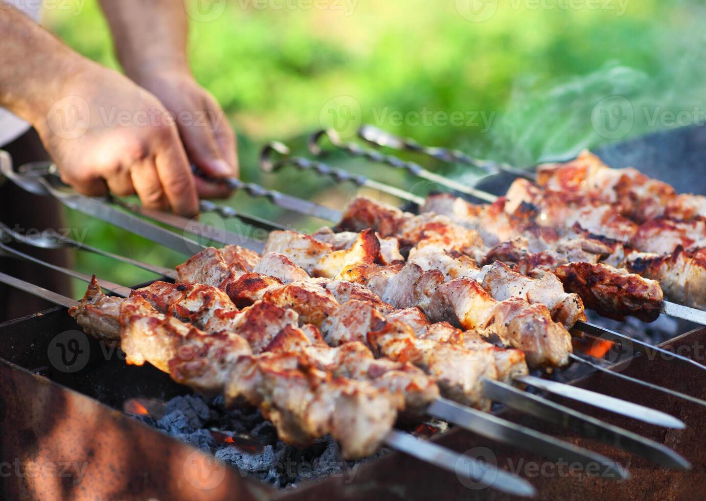 Marinated shashlik, lamb meat grilling on metal skewer, close up photo