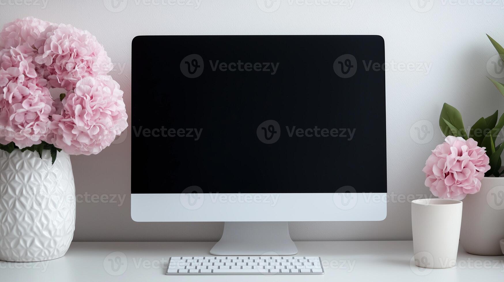 Pink hortensias near mockup computer screen on desk. Spring flowers ornament at office workplace template advertising image. Display mock up of device product photorealistic photo