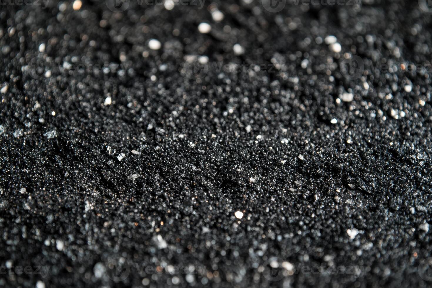 Close-up view of fine black sand with sparkling grains scattered across the surface photo