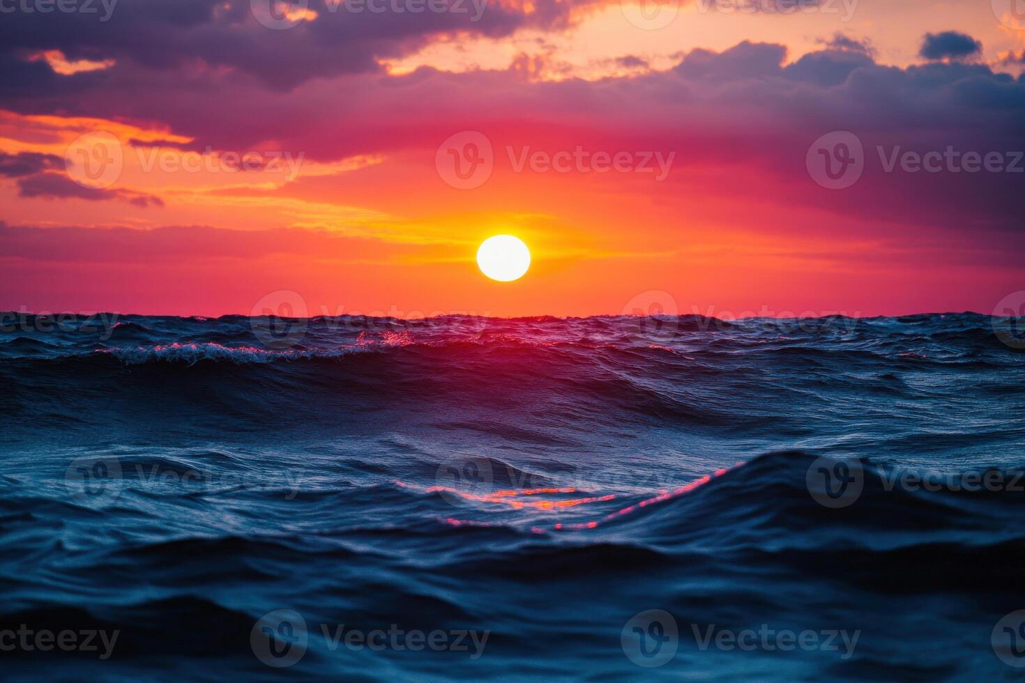 Vibrant sunset over gentle ocean waves with cloudy sky in a serene coastal setting photo