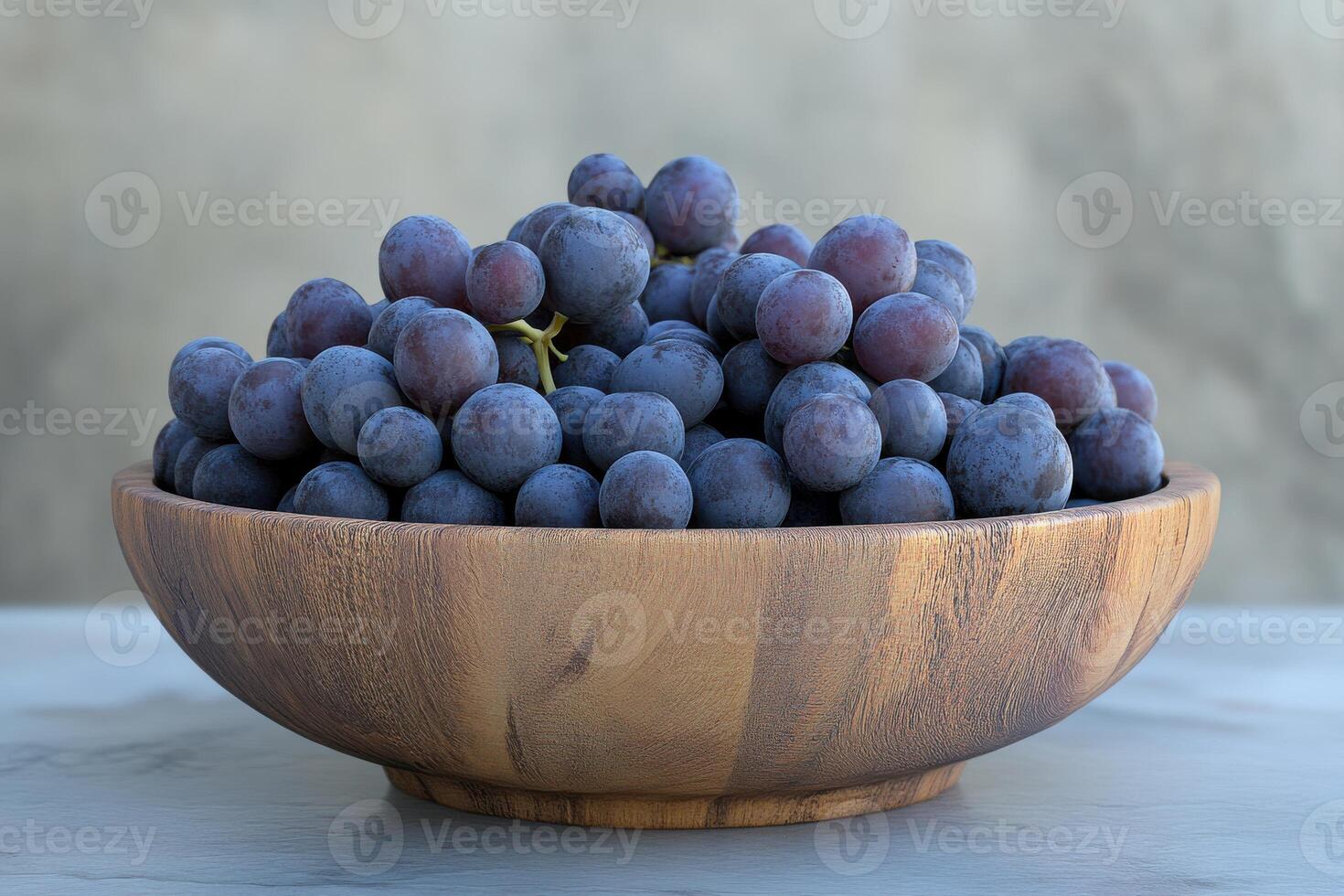 Freshly harvested grapes in a wooden bowl on a rustic surface with a natural backdrop photo