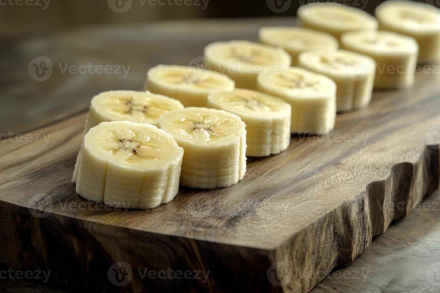 Sliced banana arranged neatly on a wooden cutting board for a healthy snack preparation photo