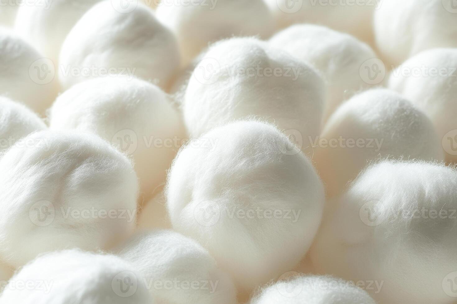 Soft, fluffy cotton balls arranged closely together on a smooth surface indoors photo