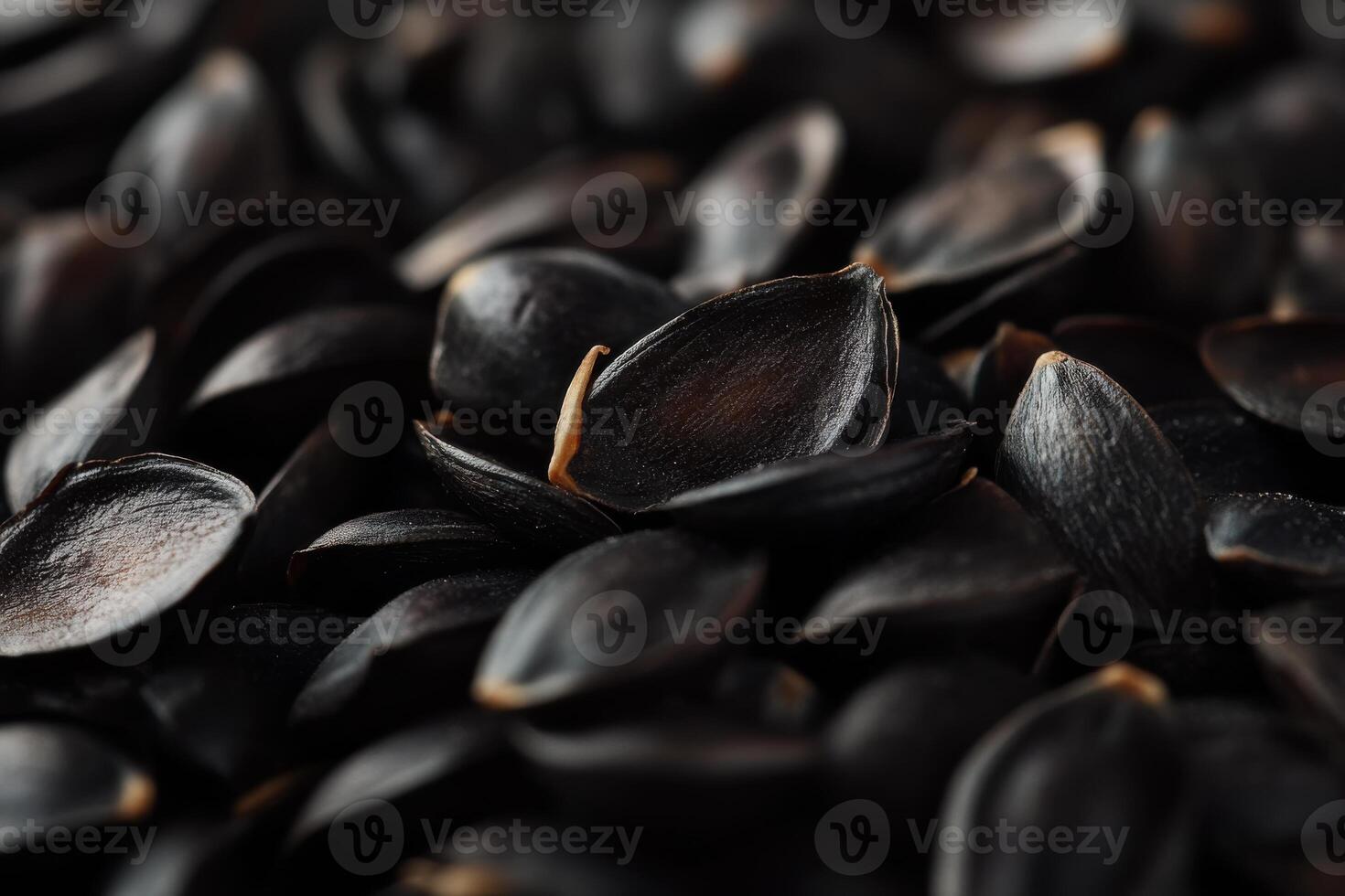 Close-up of harvested black seeds grouped together on a textured surface in natural light photo