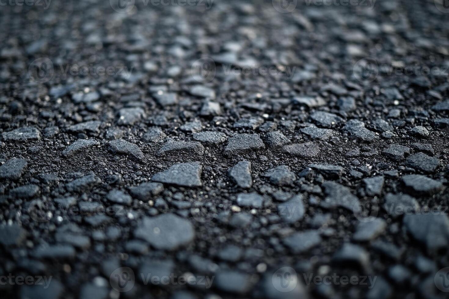 Textured close-up of asphalt ground surface showcasing various sized stones and gravel photo