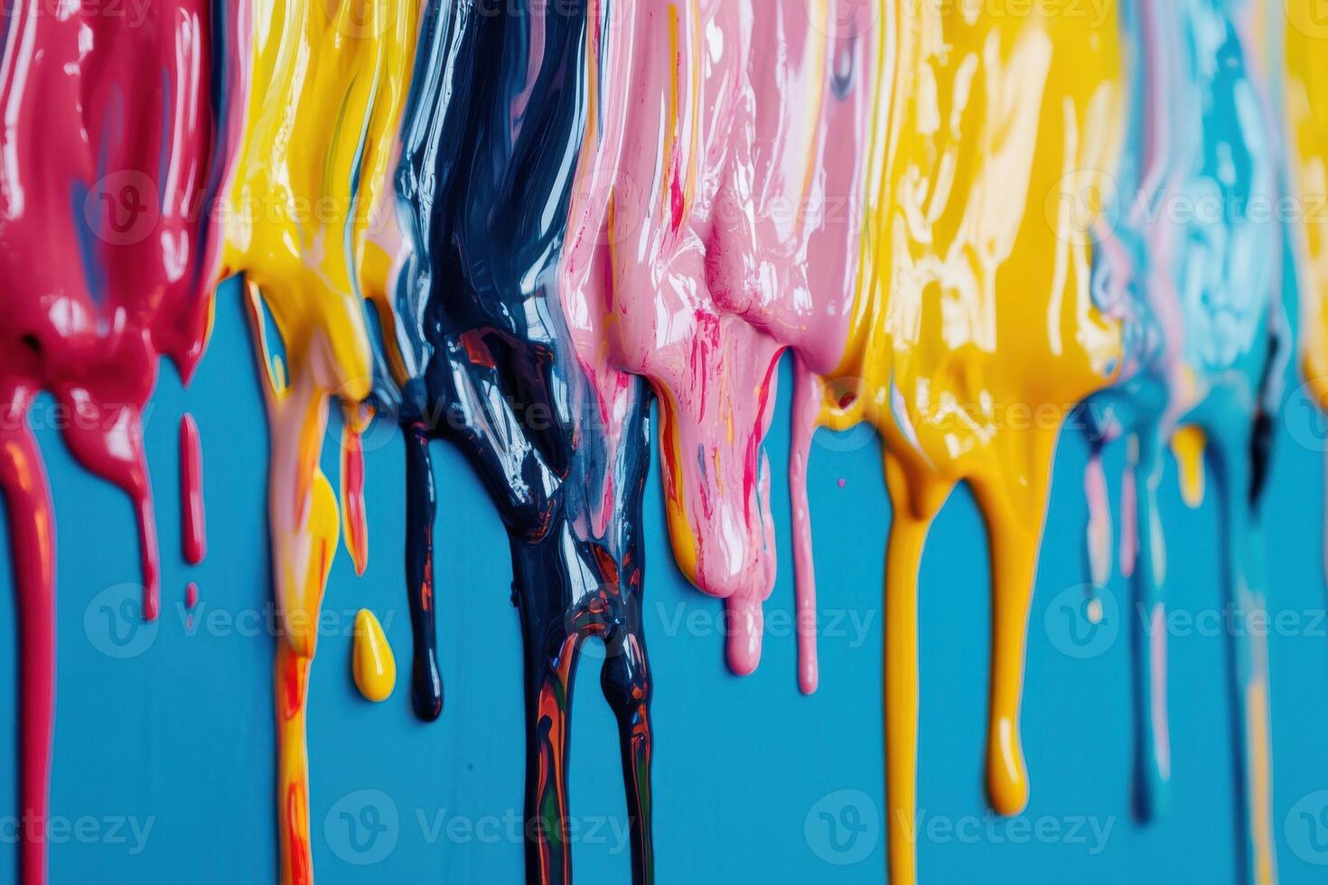 Colorful drips of paint creating an artistic display on a blue wall during a creative project photo