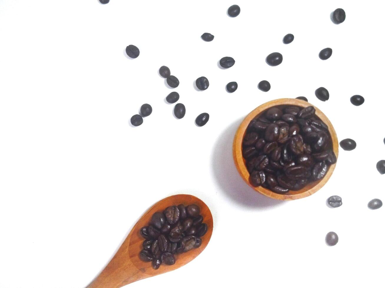 Roasted coffee bean on small wooden bowl and spoon isolated on white background with copy space photo