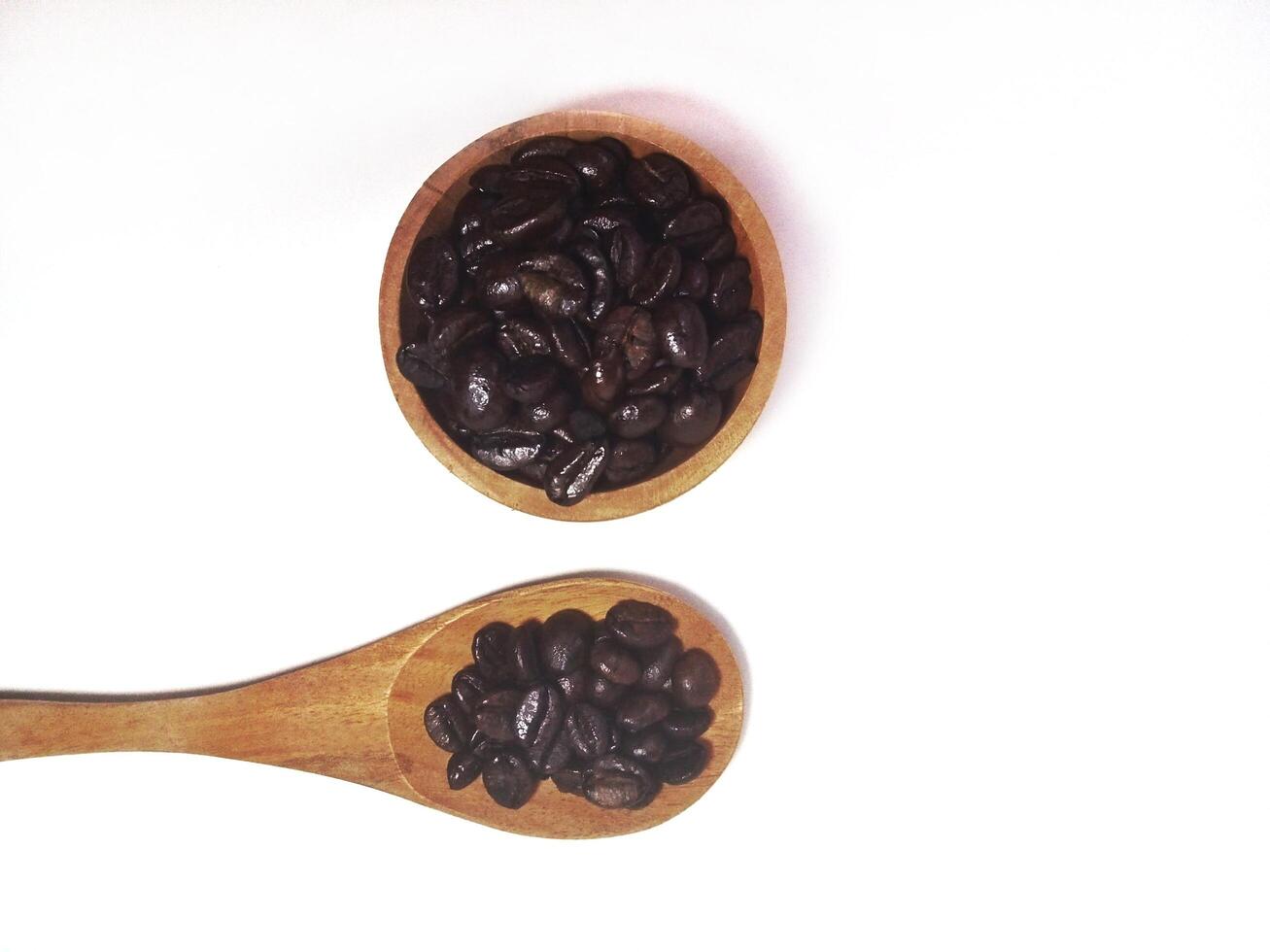Roasted coffee bean on small wooden bowl and spoon isolated on white background with copy space photo