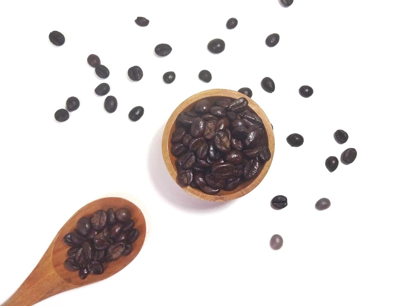 Roasted coffee bean on small wooden bowl and spoon isolated on white background with copy space photo