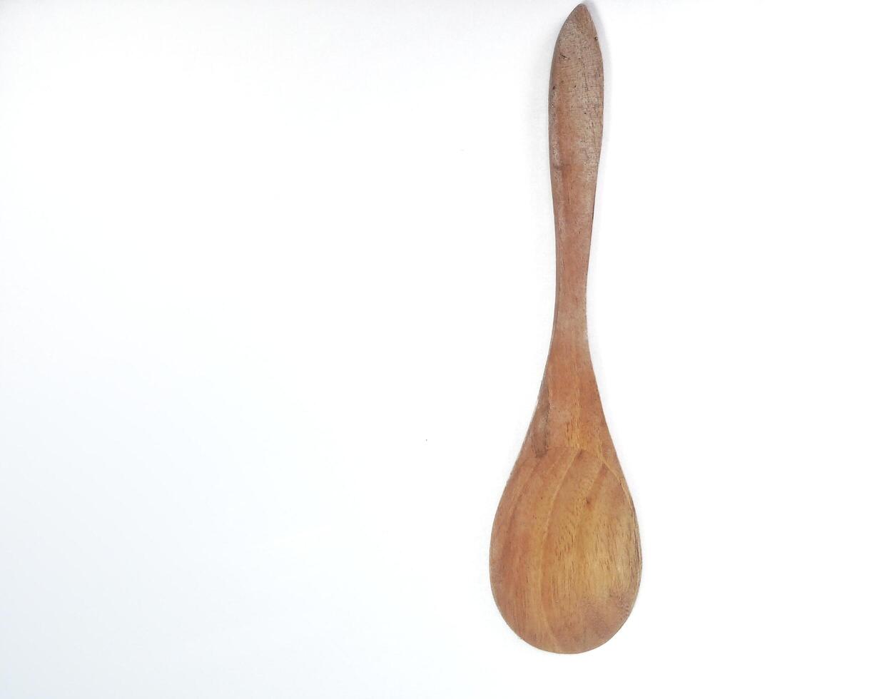 One empty brown wooden spoon isolated on white background with copy space area photo