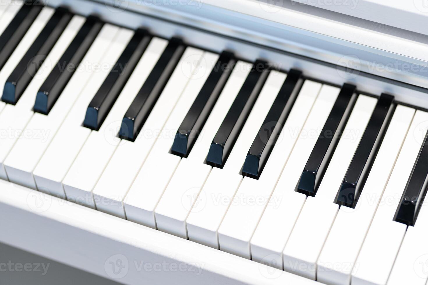 Black and white keys on a white electronic piano. Piano keys closeup. Classic piano keyboard. photo