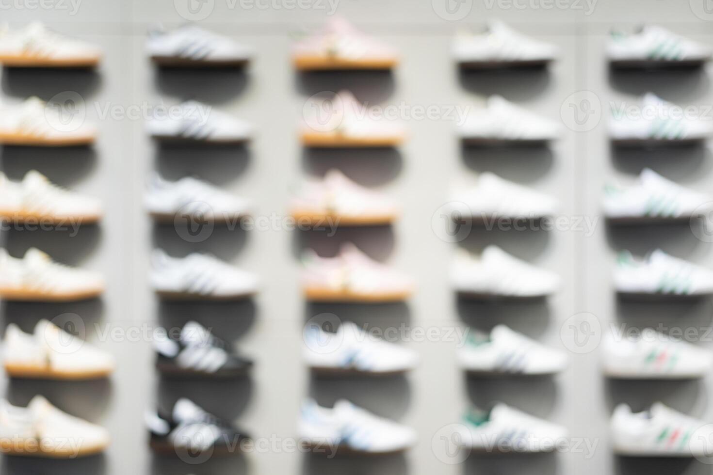 Abstract Blur Background of Row of shoes on display in shop. A view of a wall of shoes inside the store. Modern new stylish sneakers running shoes. photo