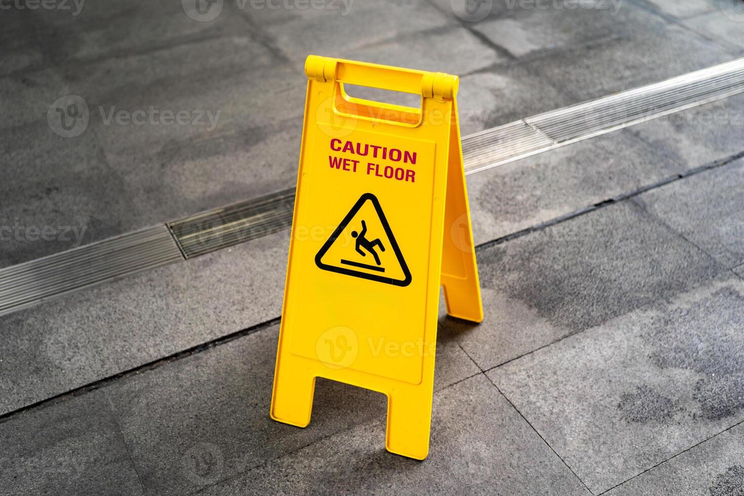 Yellow Caution slippery wet floor sign on the wet ground. Copy space. photo