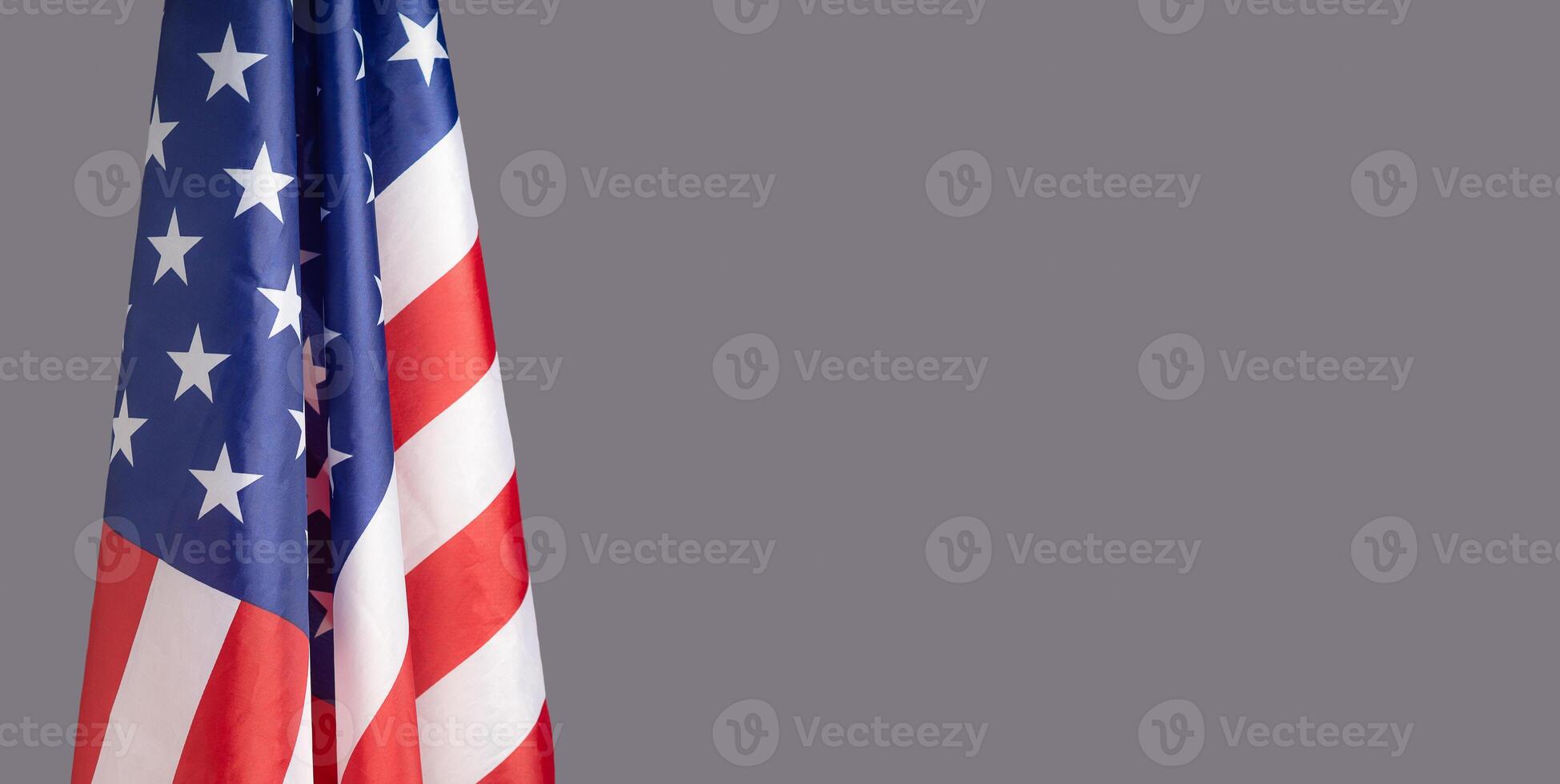 lose-up of the American flag is on the left side on a gray background photo