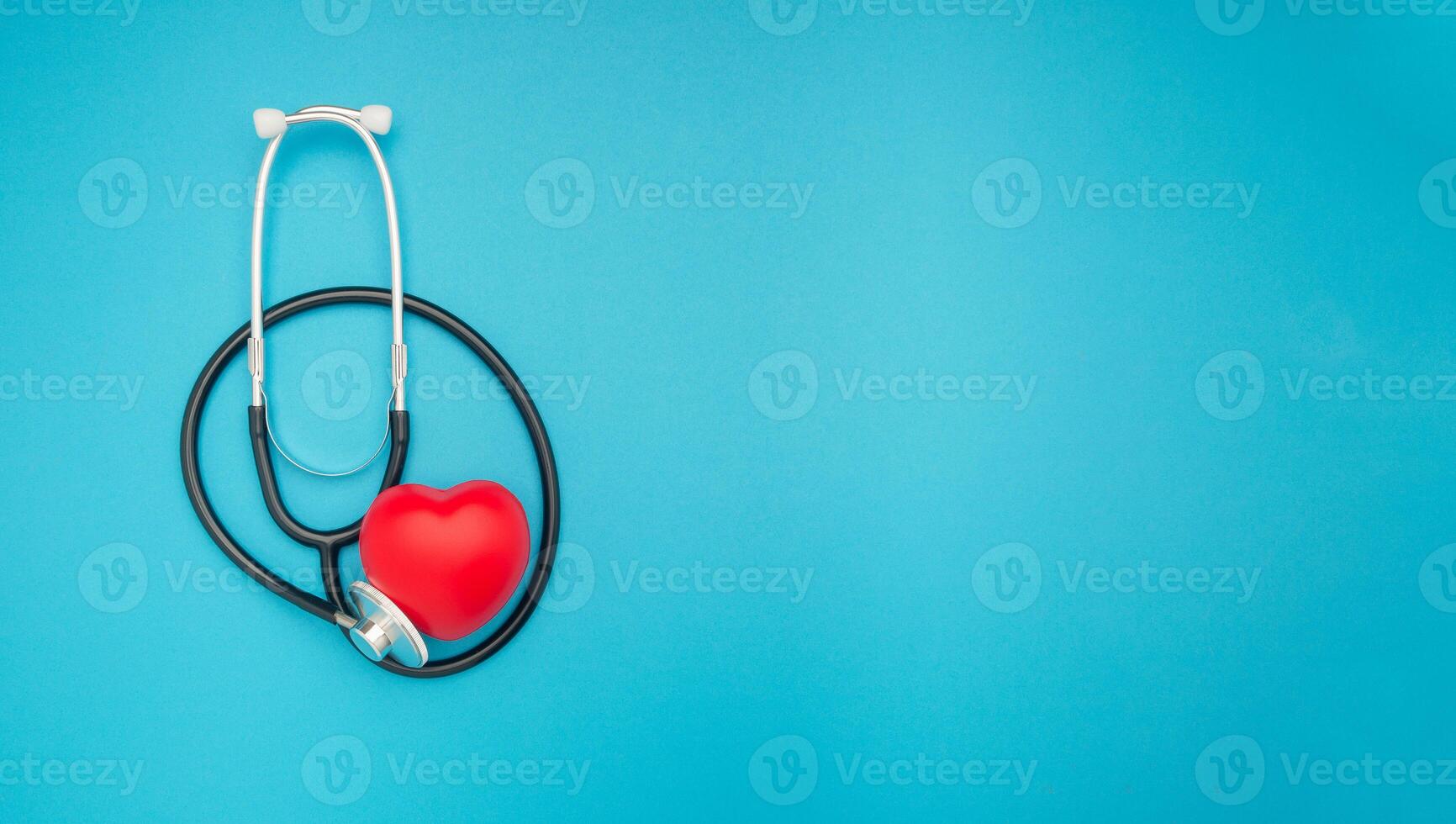 A red heart shape with a stethoscope on a blue background photo
