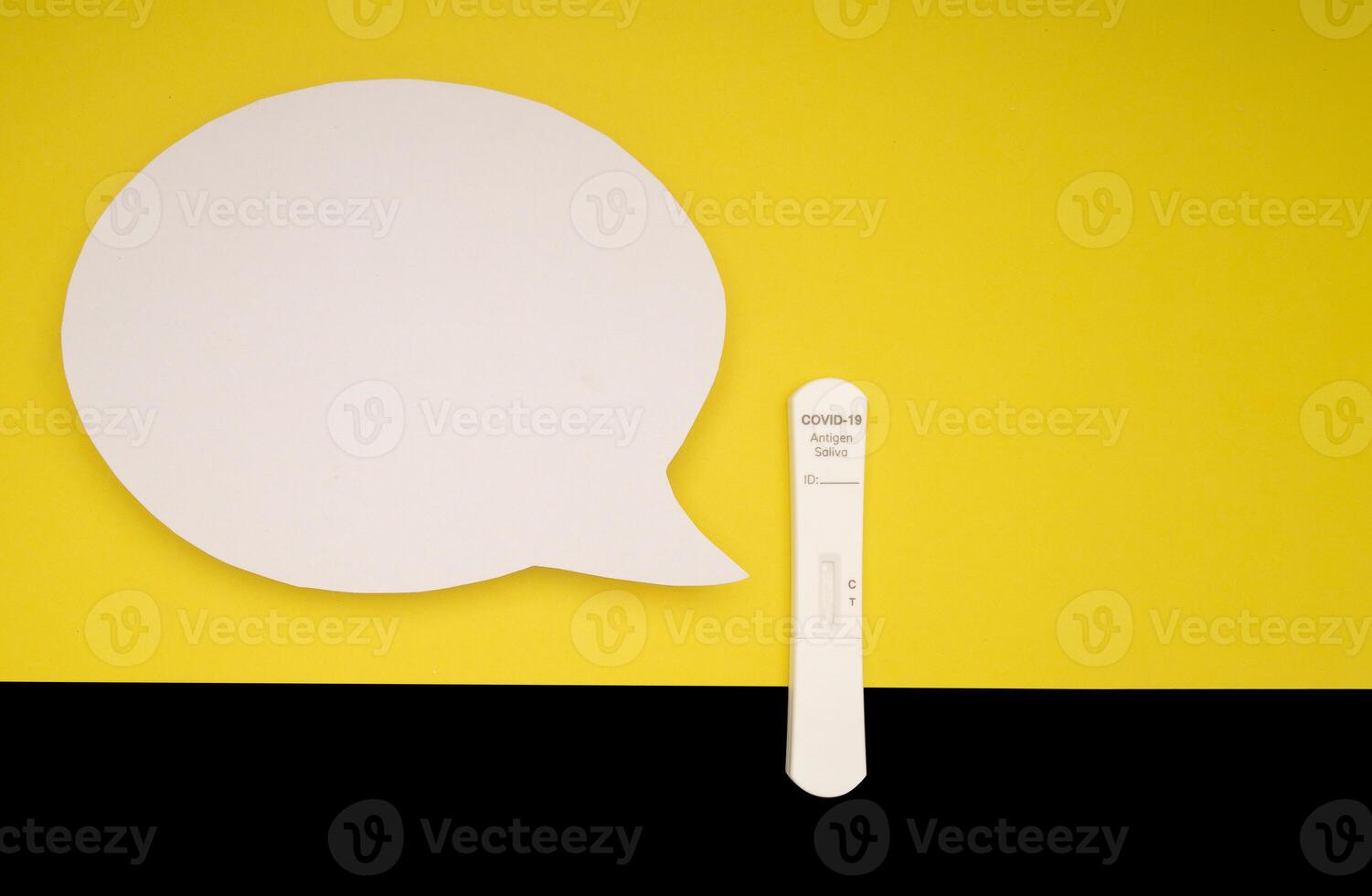 Blank white speech bubble and SARS-COV-2 Saliva Antigen Rapid Test Kit on a yellow and black background photo
