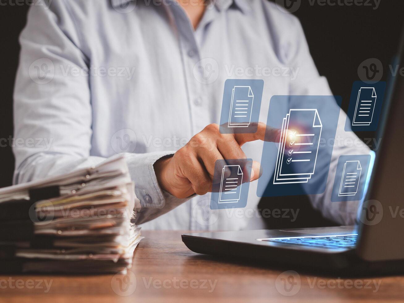 Businessman working at a laptop and digital documents with checkbox lists on virtual screen photo