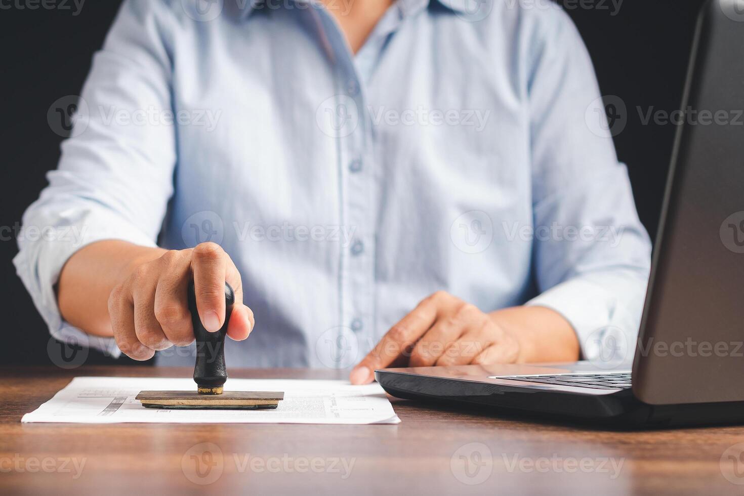 Businessman stamping approved on documents while sitting working in the office photo