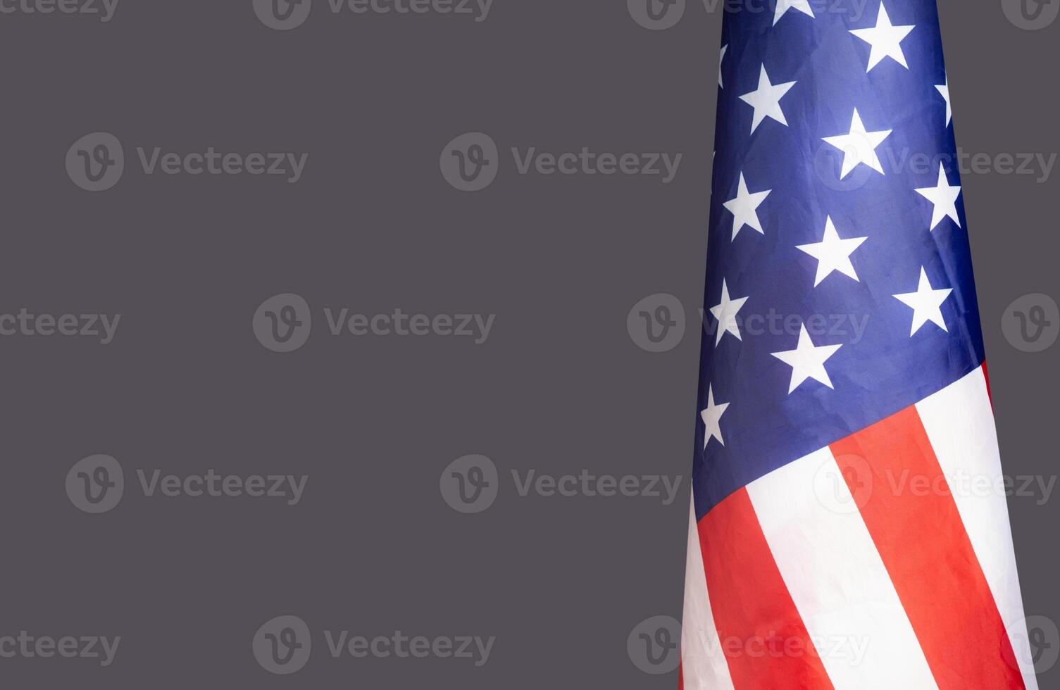 The American flag is on the right side on a gray background photo
