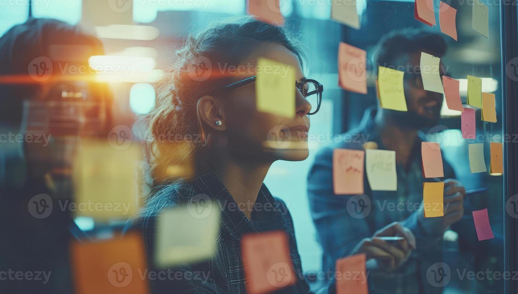 Business team brainstorming and planning with sticky notes on glass wall in office. Concept of teamwork, strategy, innovation, and project management. photo