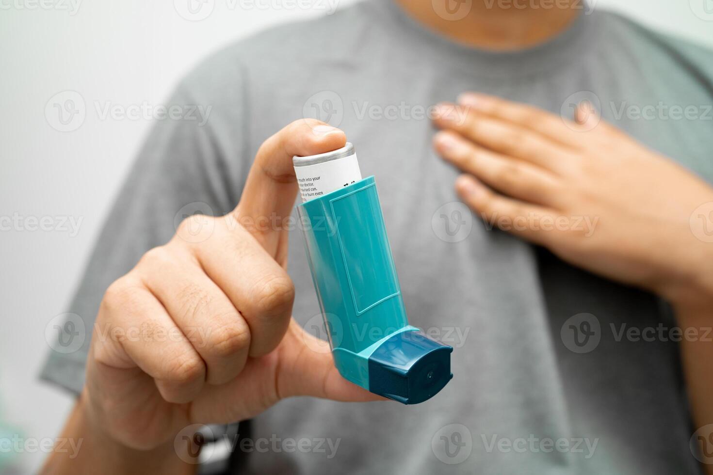 Asthma and chronic obstructive pulmonary disease COPD, Asian young man using metered dose inhaler MDI. photo