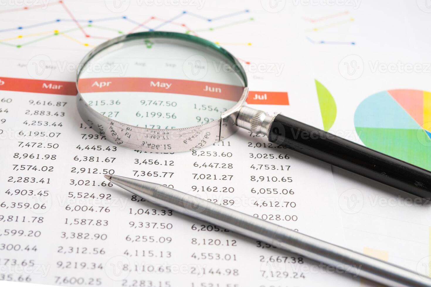 Magnifying glass on spreadsheet and graph paper. Financial development, Banking Account, Statistic, Investment Analytic research data economy, Business. photo