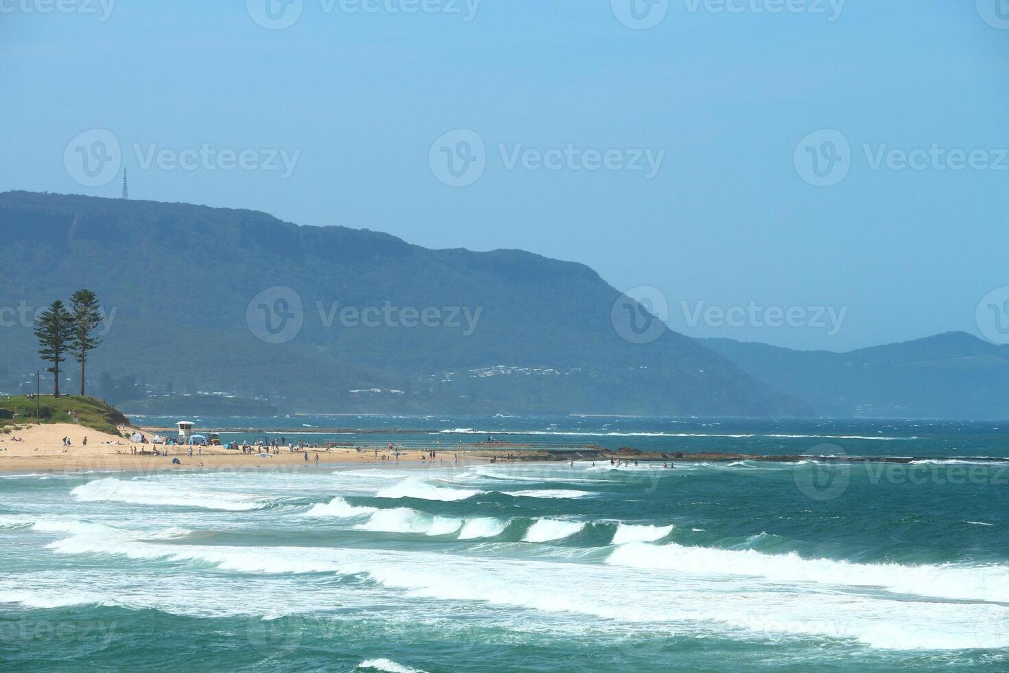 Sandy Beach With Waves Rolling In From The Blue Ocean Under A Clear Blue Sky On A Sunny Day photo