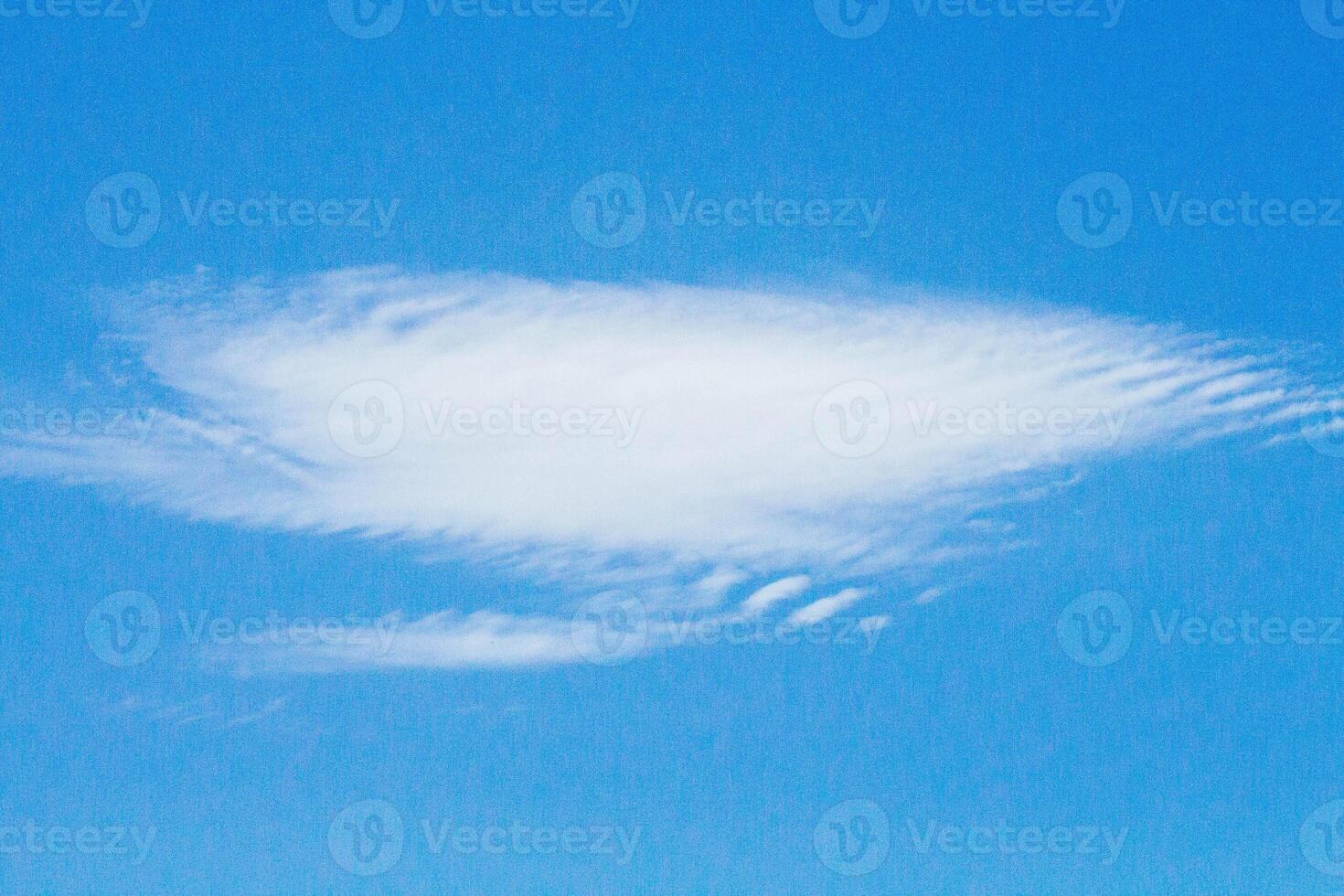Soft White Cloud Floating Against A Bright Blue Sky On A Clear Day photo