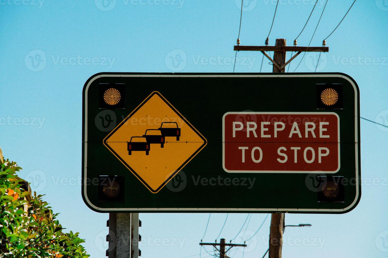 Prepare To Stop Traffic Sign With Flashing Lights Along A Busy Road Under A Bright Blue Sky photo