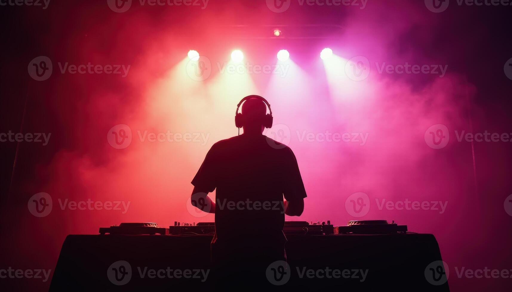 DJ Performing on Stage with Colorful Lights and Fog photo