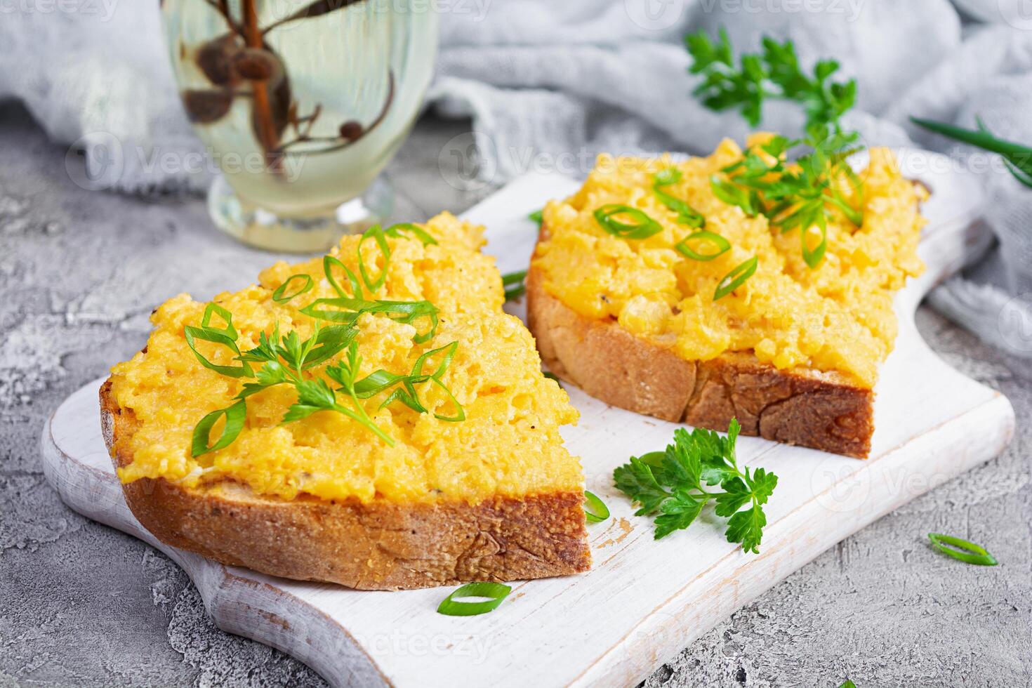 Scrambled eggs with herbs and toasts. Delicious breakfast with eggs and herbs photo