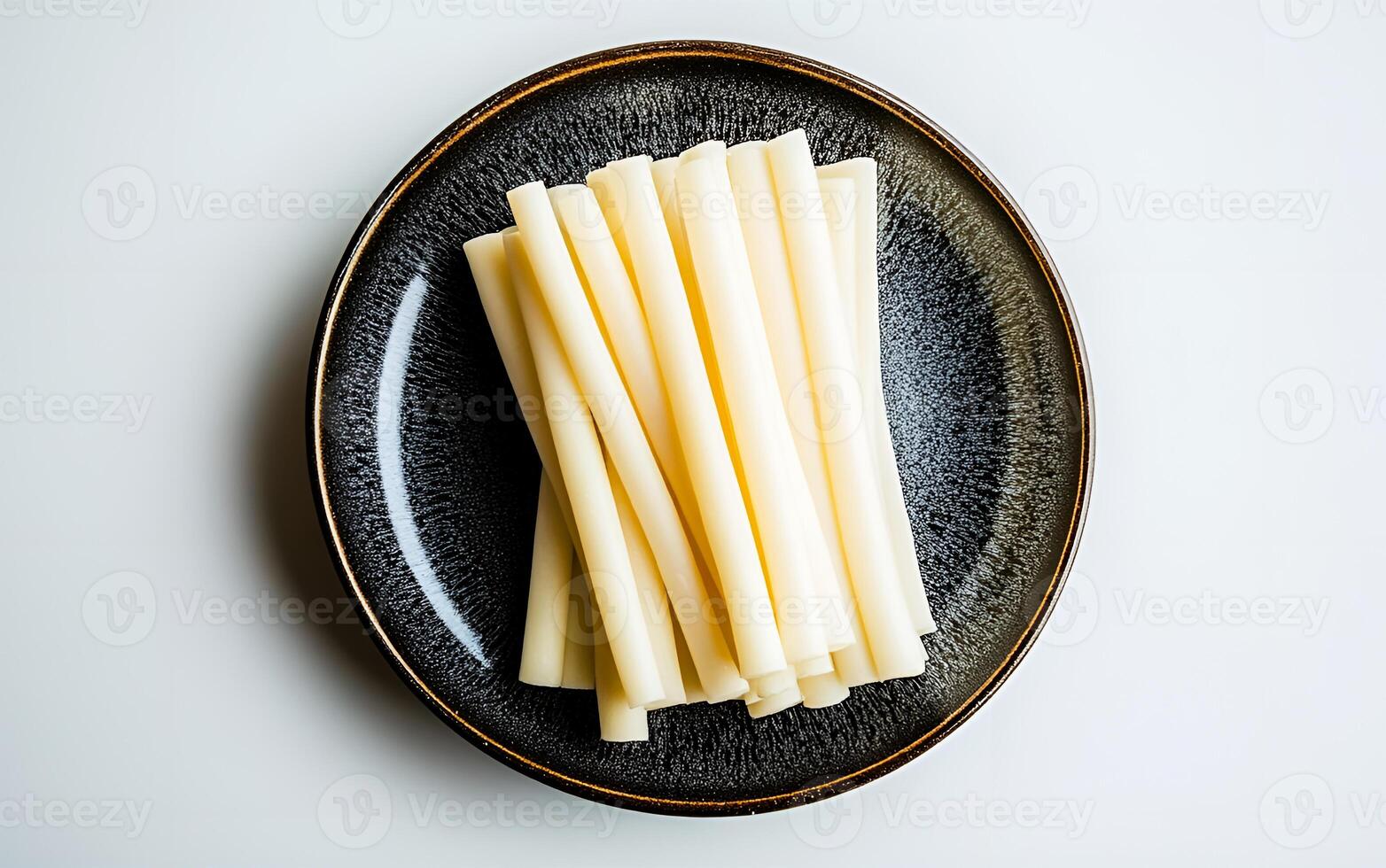 View of delicious string cheese on a plate over a white background photo