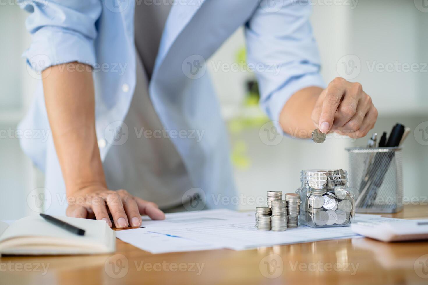Saving money. Businessman Accountant verify growing business and saving money stacking coins with calculator. Accountancy Concept. photo