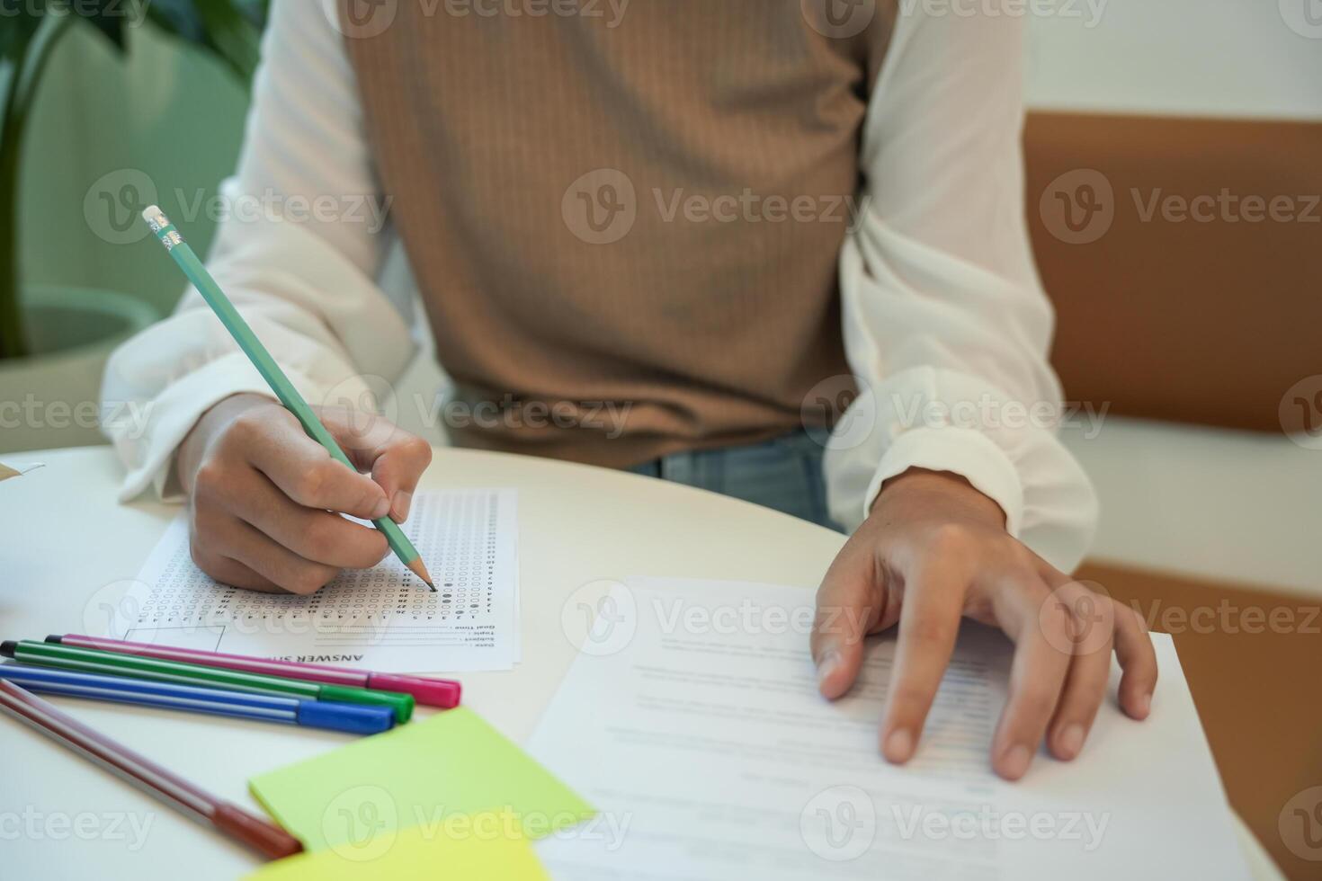 girl student reading book preparing for college exam Young female student studying and writing on notebook making in school library. photo