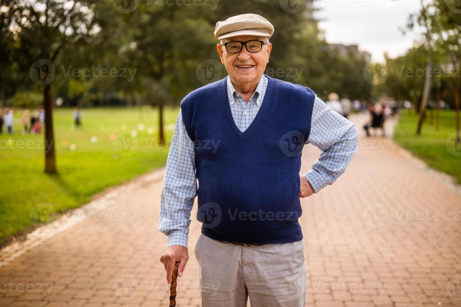 Portrait of happy senior man in park. He is relaxing and walking. photo