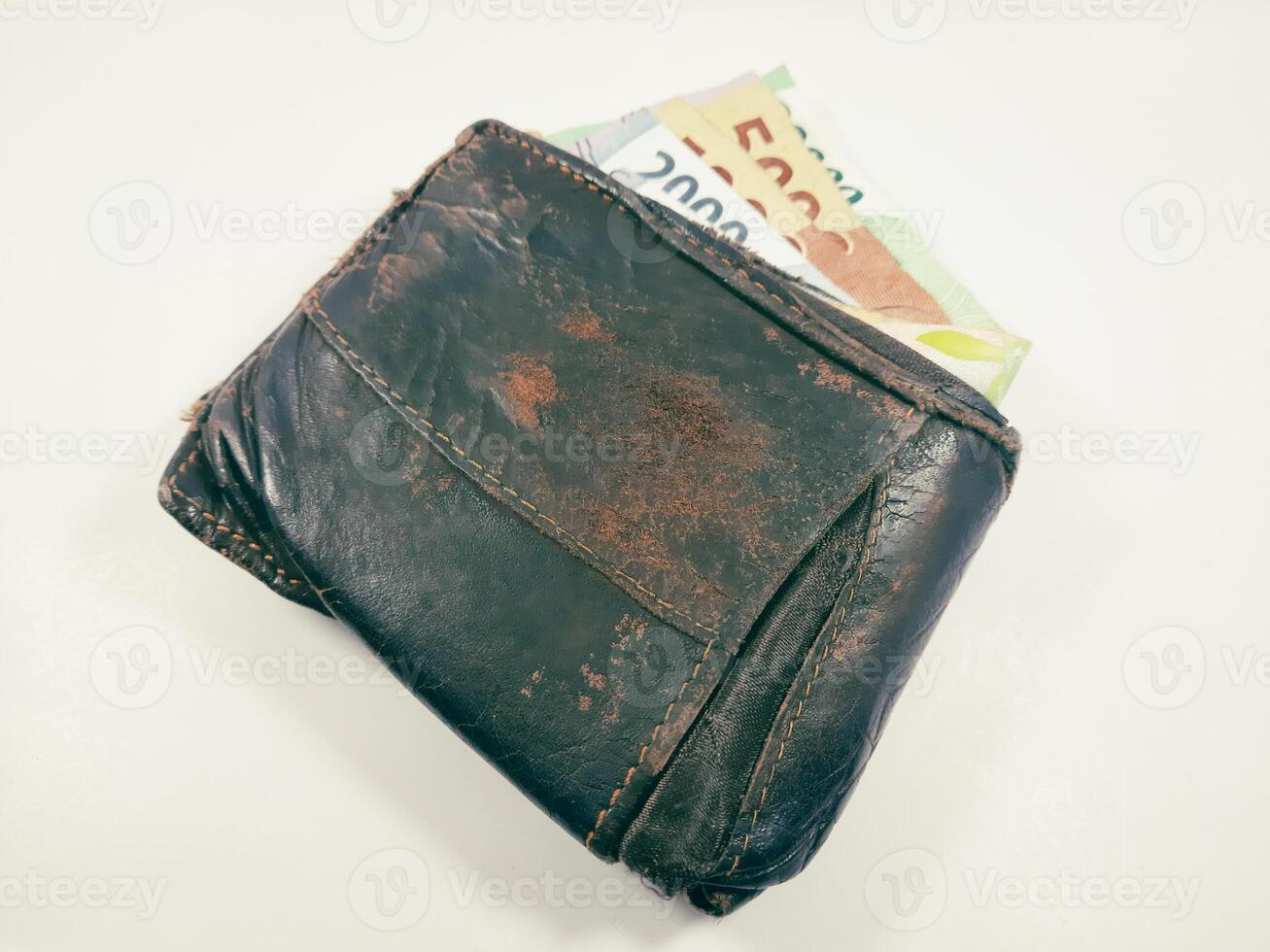 A shabby brown wallet, with a small amount of money inside, although shabby, it still works well as a cash storage. photo
