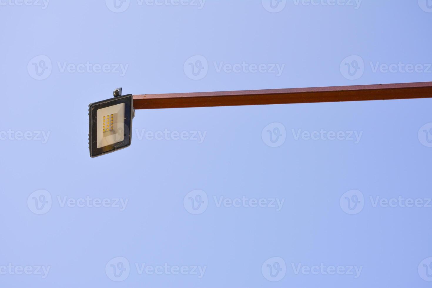 Outdoor LED light on a metal pole. LED floodlight for architectural and advertising lighting. A piece of light equipment against the clear blue sky background photo