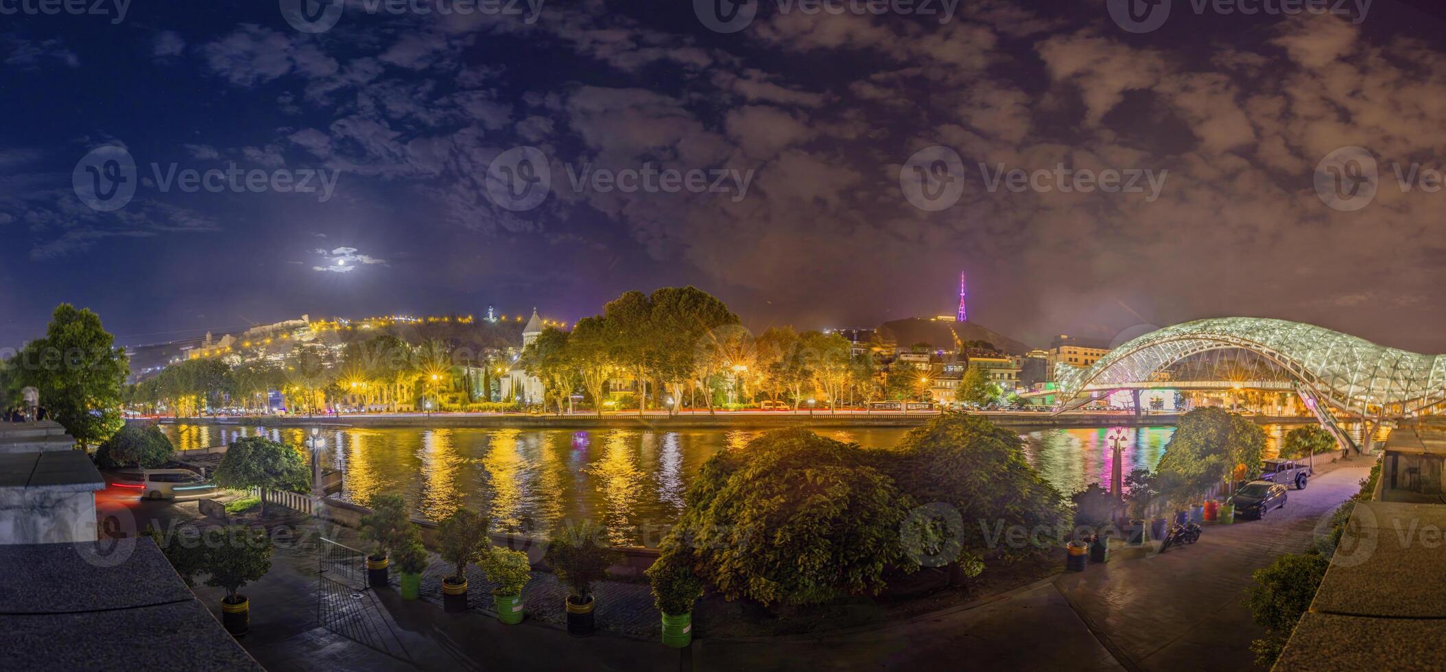 Peace Bridge in Tbilisi, Georgia, illuminated at night over the Kura River, captured in artificial light photo