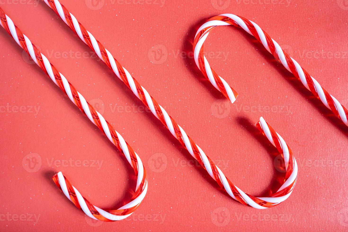 Christmas candy canes laying down on a red background. Christmas Background. photo