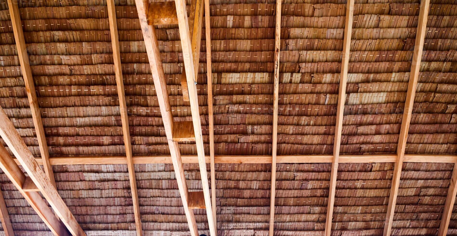 Rustic Wooden Ceiling with Exposed Beams Showcasing Natural Texture and Architectural Design in a Traditional Setting photo