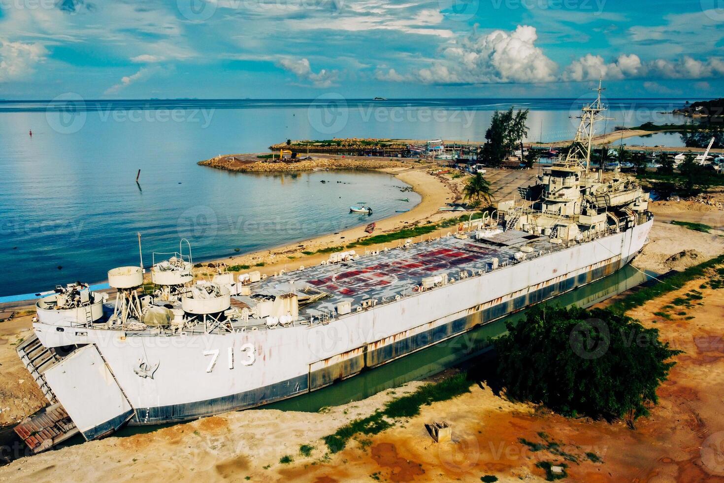 Abandoned Military Ship on Sandy Beach with Clear Blue Sky and Calm Ocean in Background photo