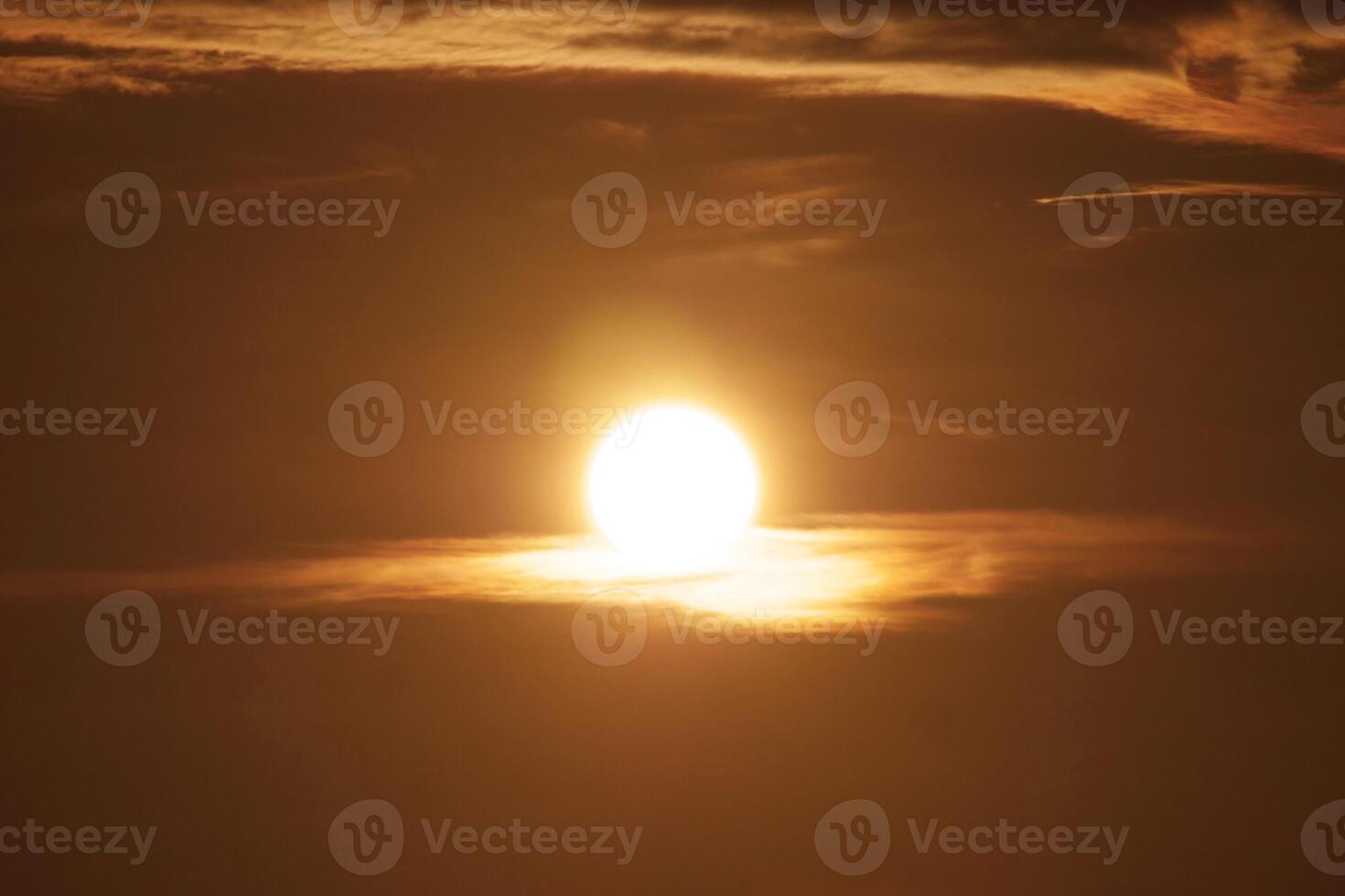Stunning Sunset with Golden Sun and Dramatic Clouds Creating a Warm and Serene Atmosphere in the Evening Sky photo