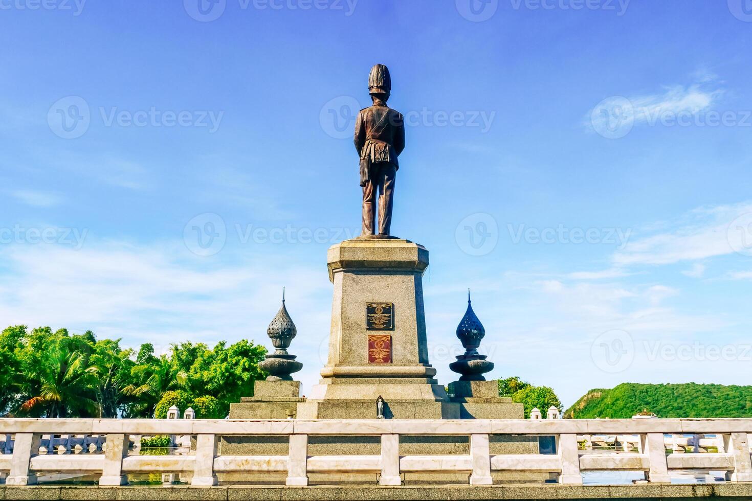 Majestic Bronze Statue on Pedestal with Clear Blue Sky and Lush Greenery in a Tranquil Park Setting photo