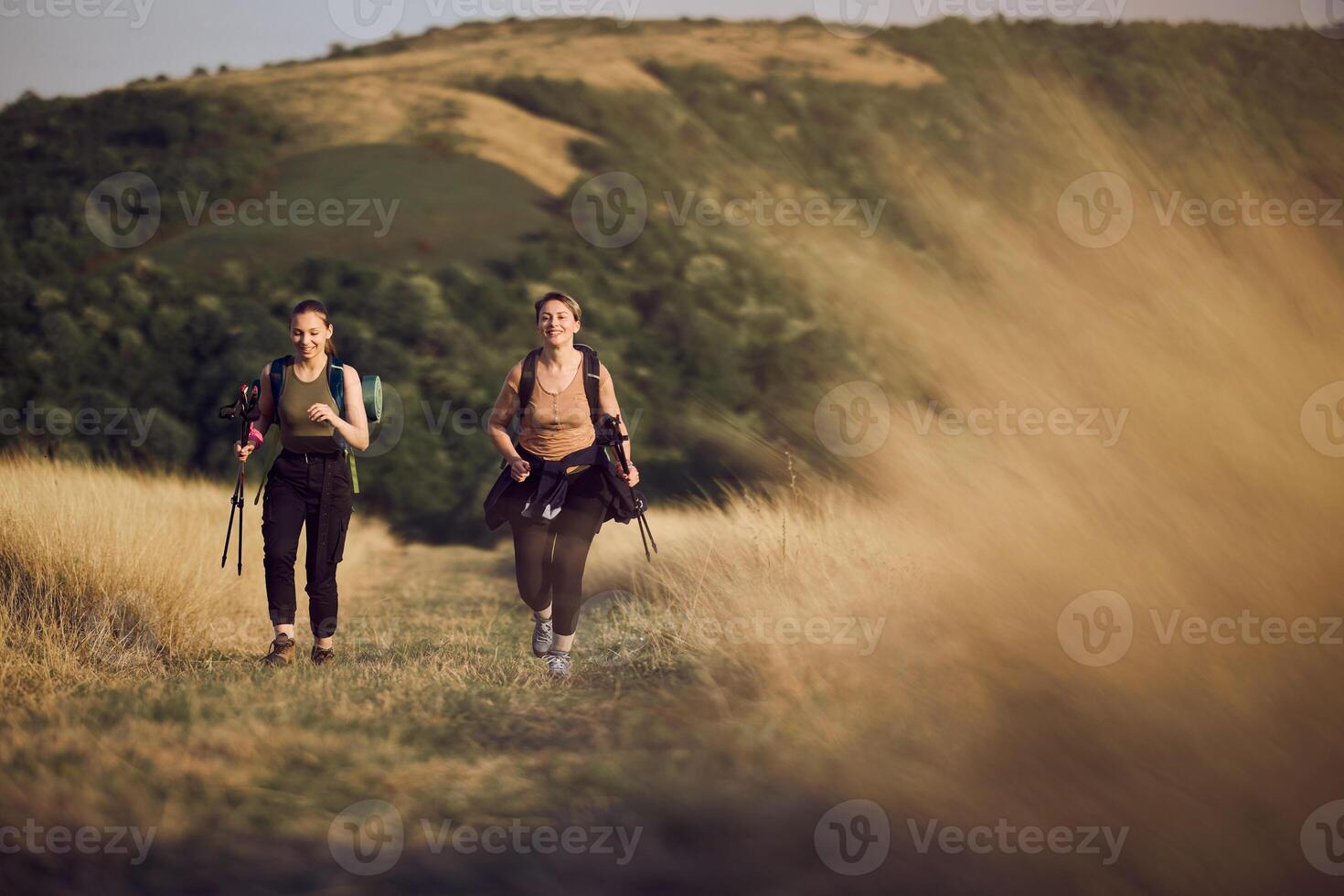 Mother And Teen Daughter Hiking On Mountain photo