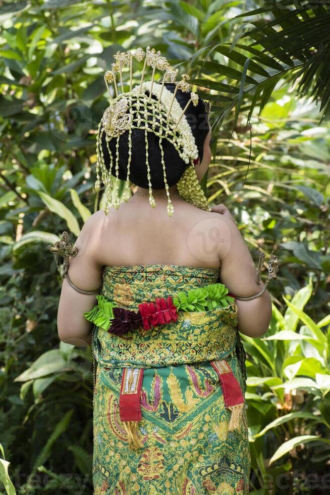 Back view of a bride in traditional Javanese bridal clothing called basahan. photo