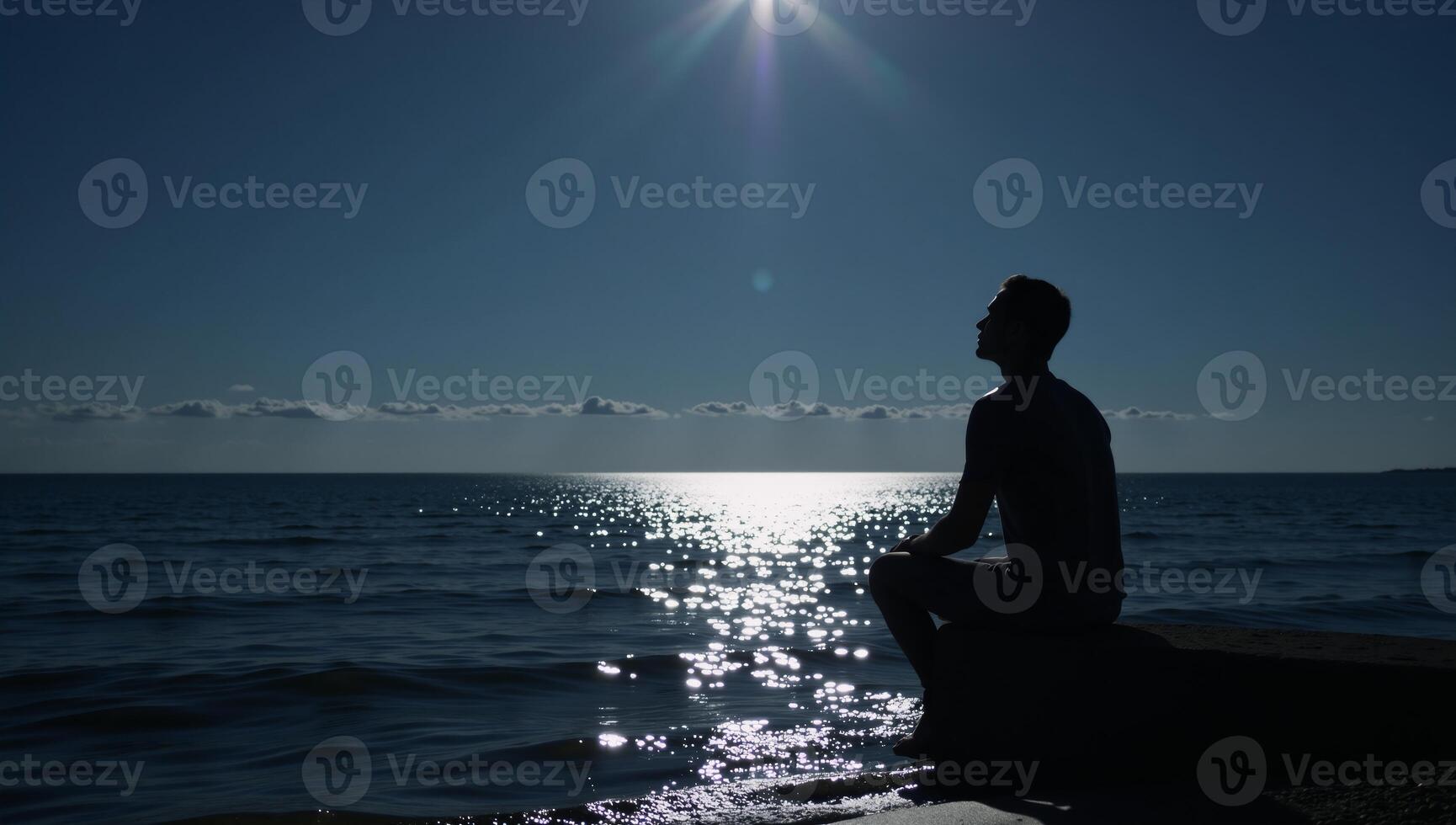 Lone figure contemplates under moonlit sky by waters edge photo
