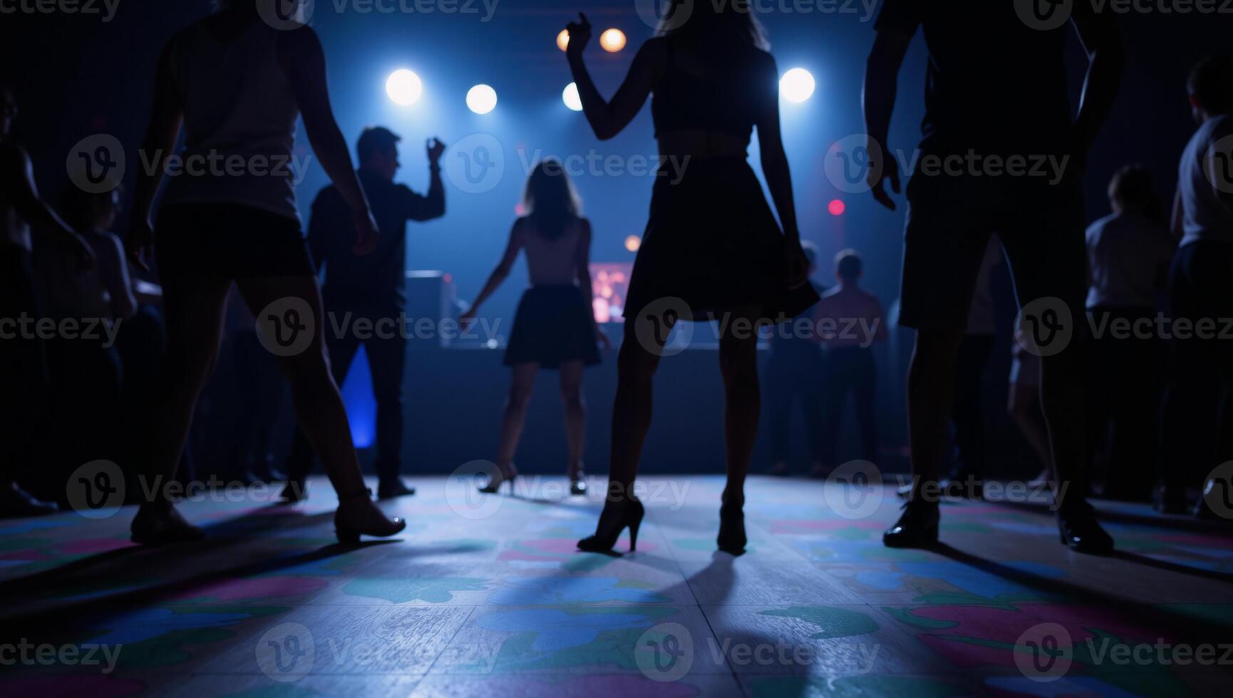 People silhouetted dancing at a club scene with a blurry backdrop photo