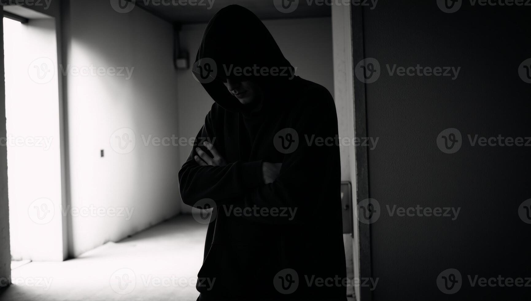 A hooded criminal or hacker is depicted with a dark silhouette in an ominous and faceless portrayal photo
